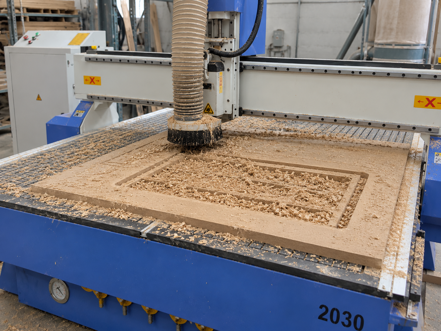 CNC router cutting area showing dust shoe and chip residue after machining